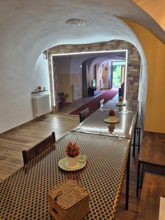 Sala da pranzo di Casa Regina 21 con tavolo lungo e soffitti a volta