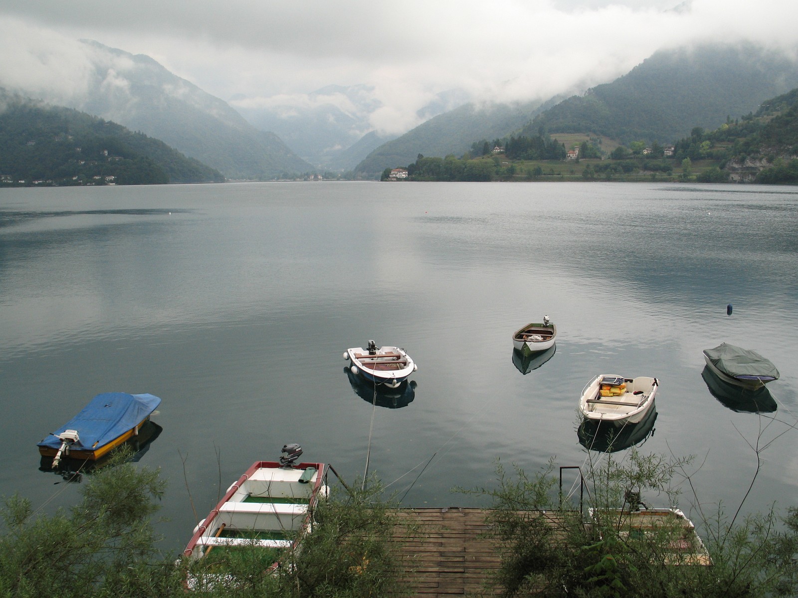 Barche ormeggiate sul Lago di Ledro con le montagne sullo sfondo