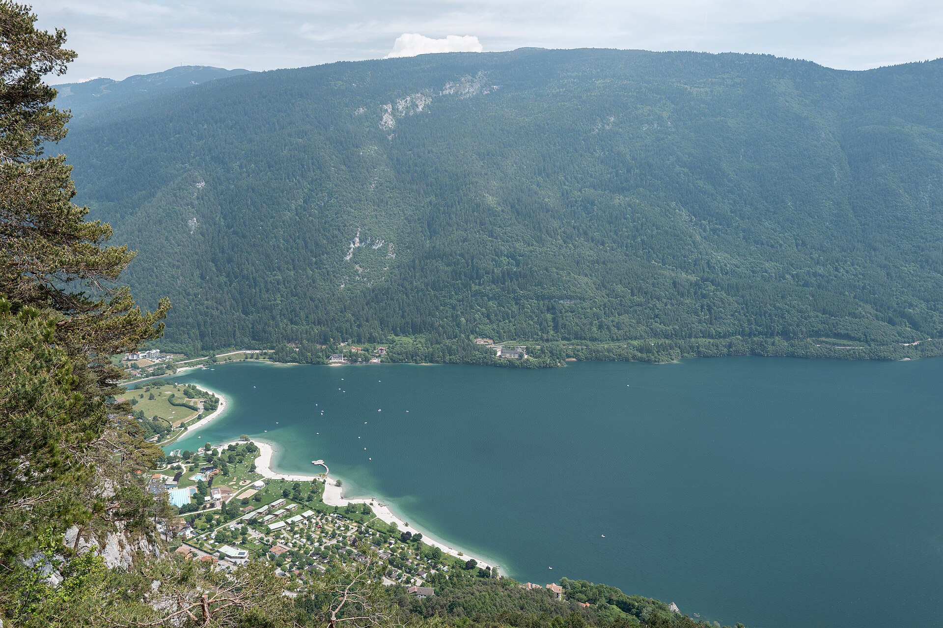Lido e spiagge del Lago di Molveno visti dall’alto sotto le montagne boscose