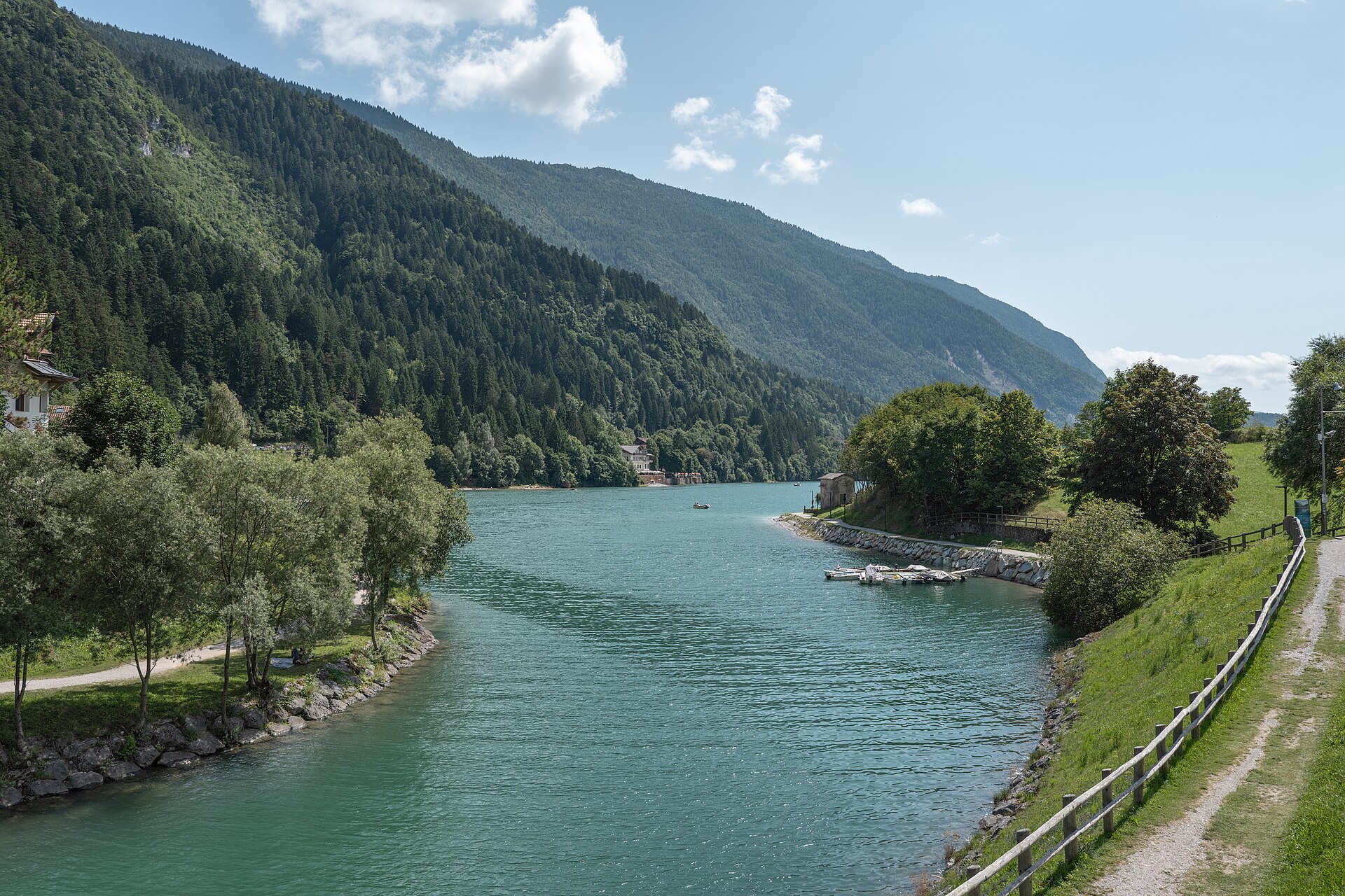 Sentiero lungo l’acqua e piccole barche sulla riva nord del Lago di Molveno